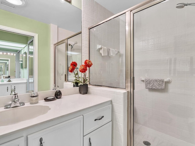 bathroom with vanity and a shower with door