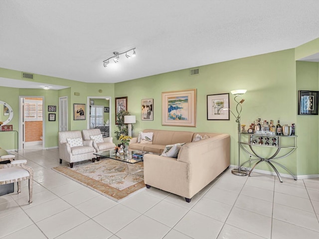 living room featuring light tile patterned floors, a textured ceiling, and rail lighting