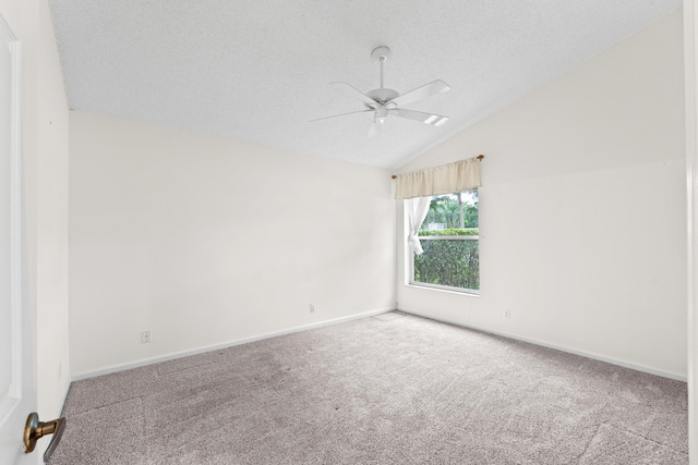 carpeted empty room featuring lofted ceiling, ceiling fan, and a textured ceiling