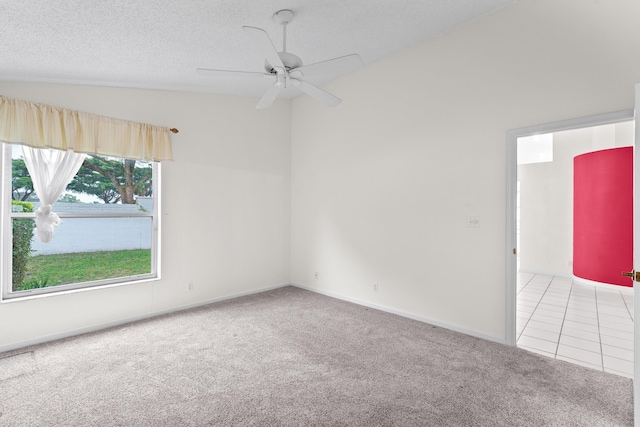 spare room with vaulted ceiling, ceiling fan, a textured ceiling, and carpet floors