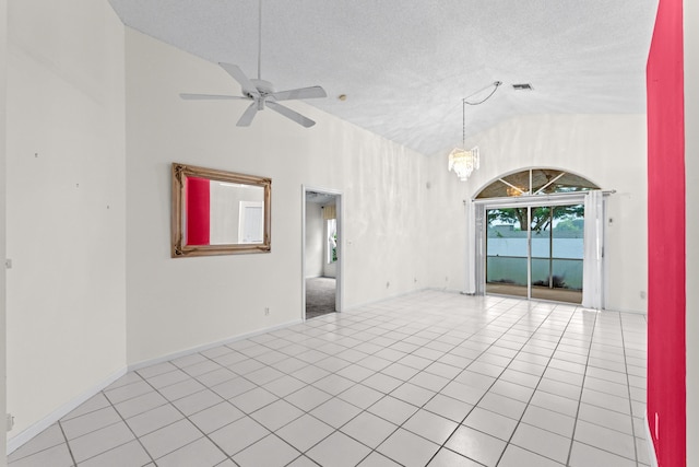 tiled empty room featuring a textured ceiling, lofted ceiling, and ceiling fan with notable chandelier