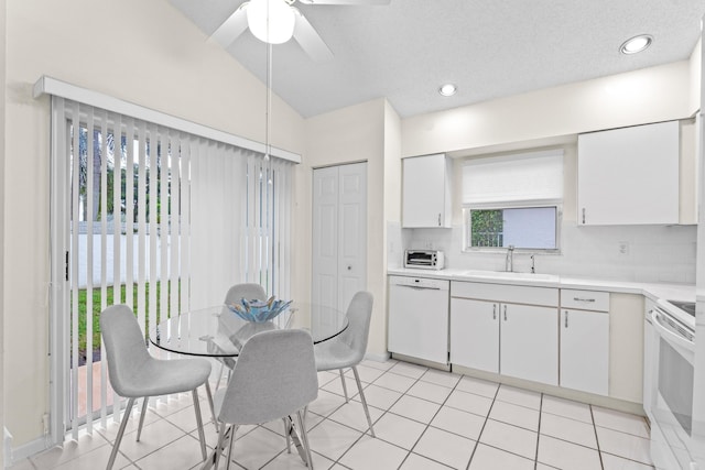 kitchen featuring lofted ceiling, white cabinets, sink, and white appliances