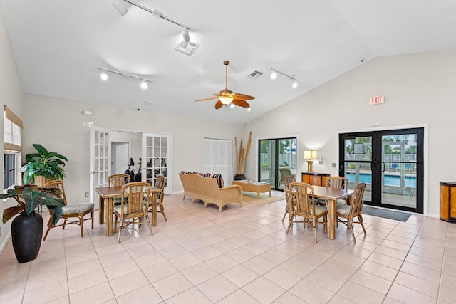 tiled dining space featuring ceiling fan, french doors, and high vaulted ceiling