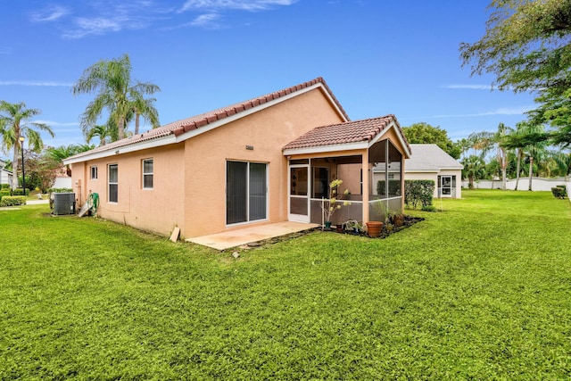 rear view of property with a lawn, central air condition unit, a patio area, and a sunroom