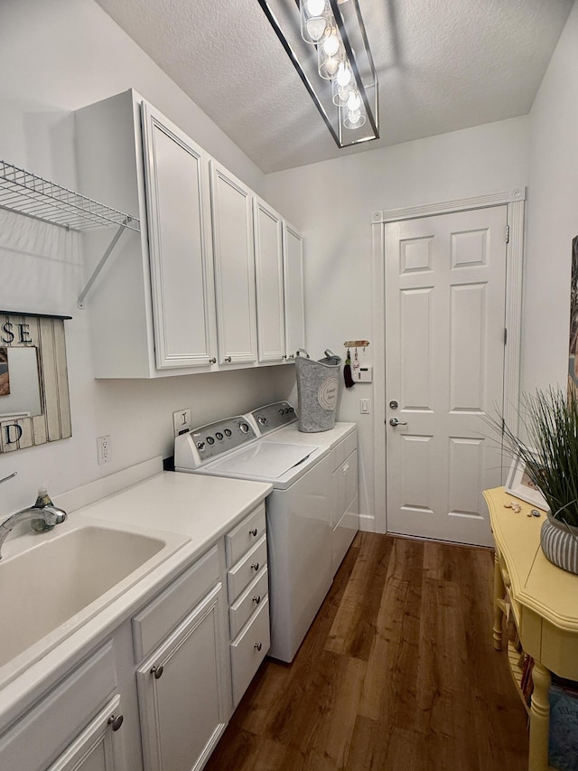 washroom with independent washer and dryer, sink, dark wood-type flooring, a textured ceiling, and cabinets