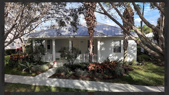 3289 Wymberly Dr, Jupiter, FL 33458 - view of front of house featuring a porch, a standing seam roof, and metal roof