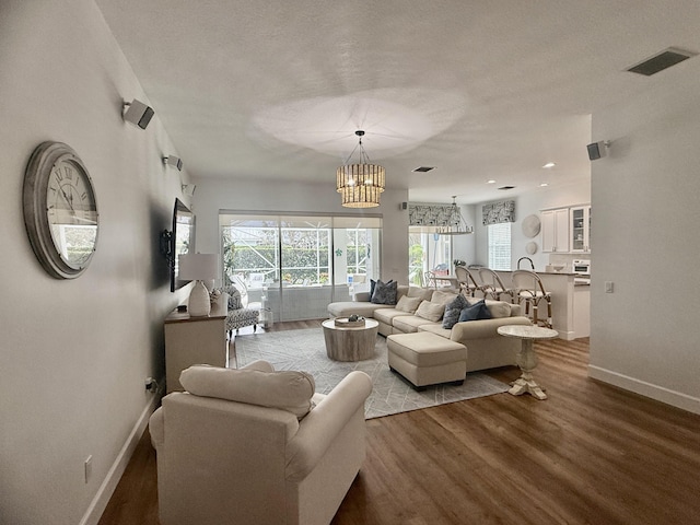 living room with an inviting chandelier and light hardwood / wood-style flooring