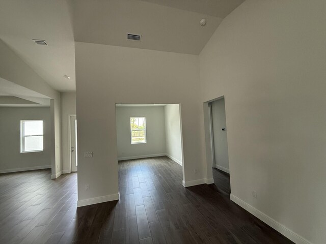 14042 82nd St N, The Acreage, FL 33470 - empty room featuring high vaulted ceiling, dark wood-type flooring, baseboards, and a smoke detector