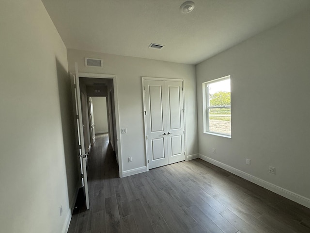 14042 82nd St N, The Acreage, FL 33470 - unfurnished bedroom with baseboards, dark wood finished floors, and a closet