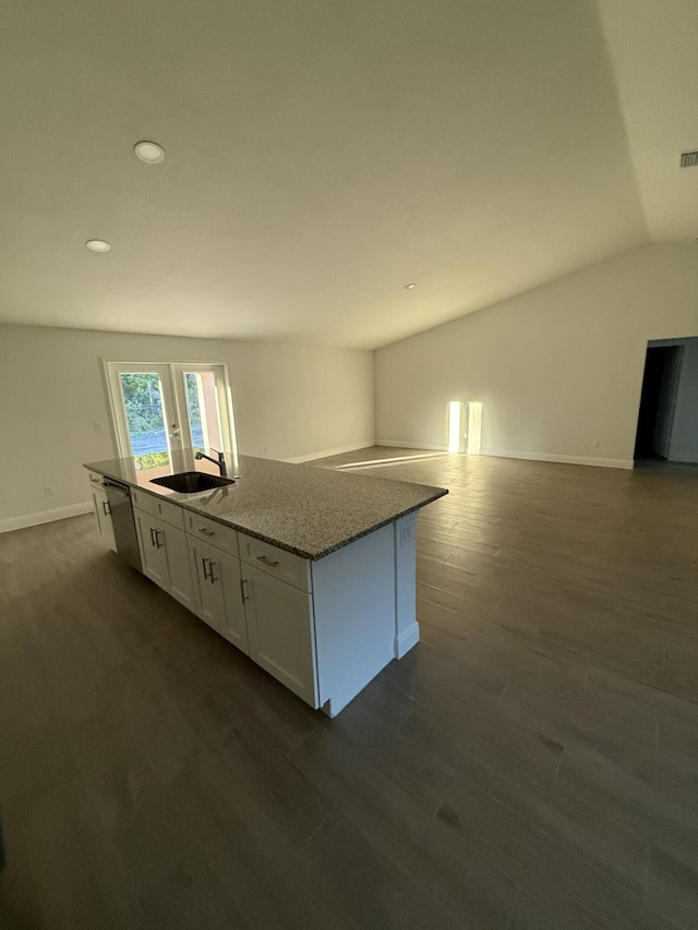 kitchen featuring white cabinetry, a center island with sink, lofted ceiling, stainless steel dishwasher, and sink