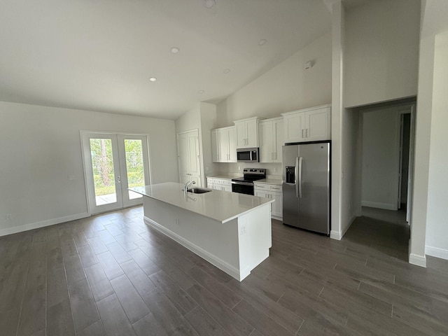 14042 82nd St N, The Acreage, FL 33470 - kitchen featuring appliances with stainless steel finishes, white cabinets, an island with sink, high vaulted ceiling, and baseboards