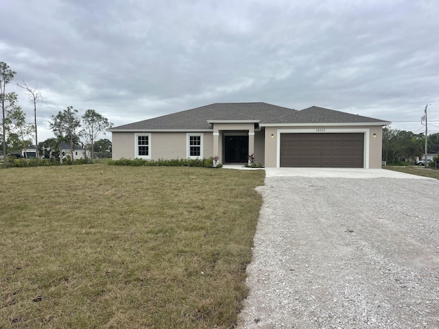 14042 82nd St N, The Acreage, FL 33470 - view of front of home featuring gravel driveway, stucco siding, a garage, a front lawn, and a shingled roof