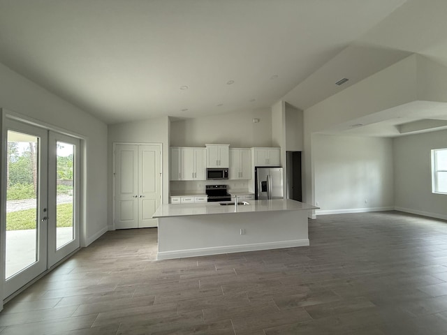 14042 82nd St N, The Acreage, FL 33470 - kitchen with stainless steel appliances, a center island with sink, white cabinetry, a sink, and light countertops