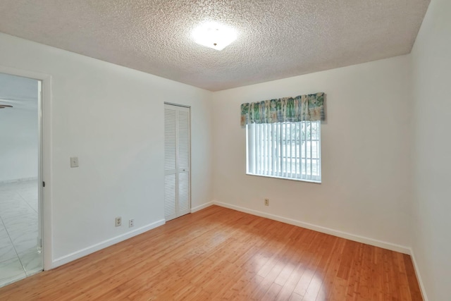 spare room with a textured ceiling and hardwood / wood-style flooring