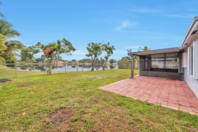 view of yard with a water view, a patio, and a sunroom