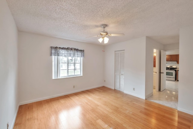 unfurnished room featuring ceiling fan, a textured ceiling, and light wood-type flooring