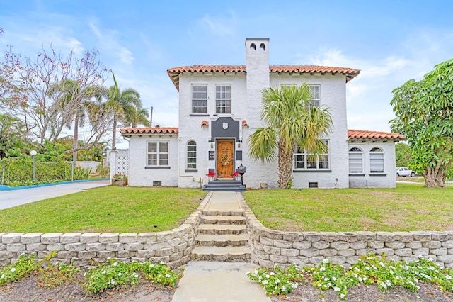 mediterranean / spanish home featuring a front yard