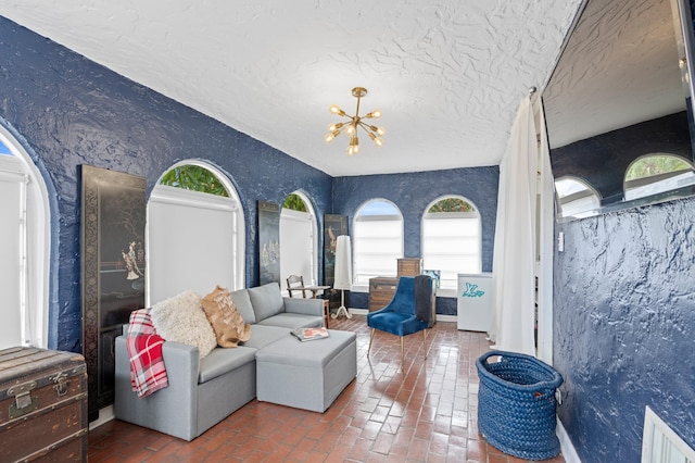 living room featuring a textured ceiling and a notable chandelier