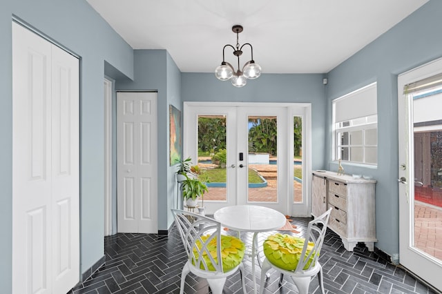 dining space featuring french doors and a notable chandelier