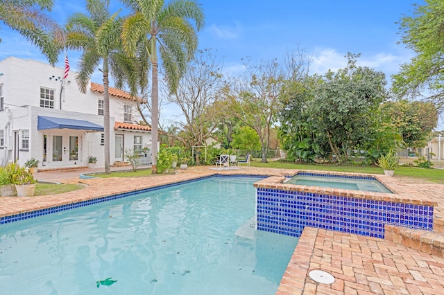 view of swimming pool featuring french doors and an in ground hot tub