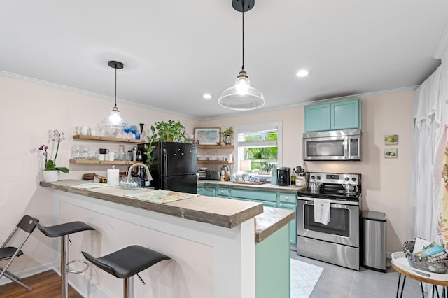 kitchen with kitchen peninsula, appliances with stainless steel finishes, crown molding, and a breakfast bar area