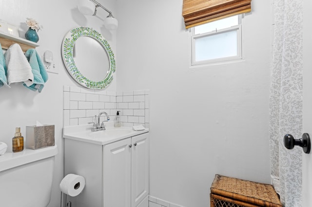 bathroom with tasteful backsplash, vanity, and toilet