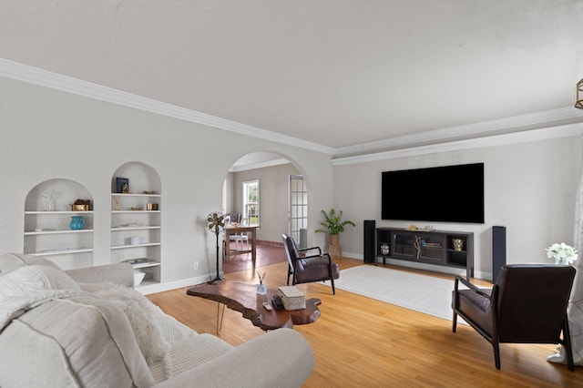 living room featuring built in features, ornamental molding, and hardwood / wood-style floors