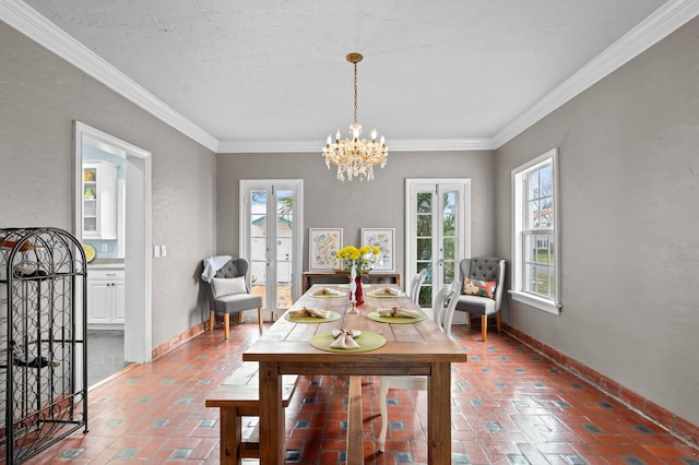 dining space with a textured ceiling, an inviting chandelier, crown molding, and french doors