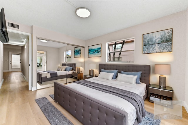 bedroom with light hardwood / wood-style flooring and a closet