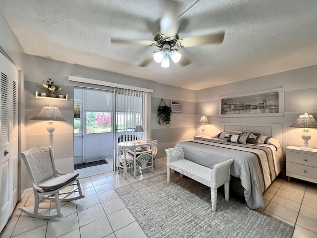 tiled bedroom featuring ceiling fan, a closet, access to exterior, and a textured ceiling