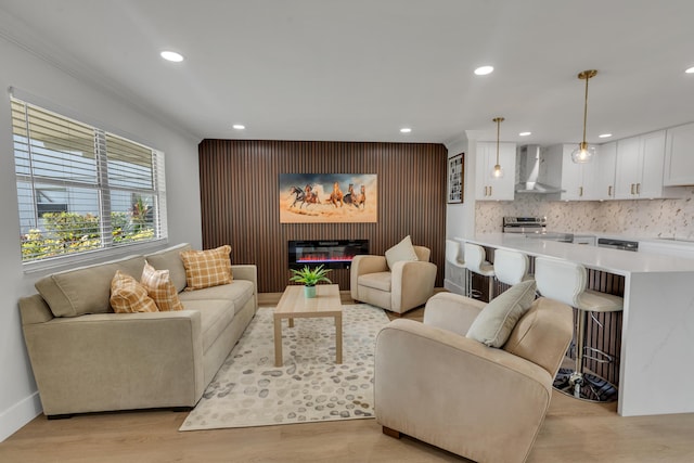 living room with crown molding and light hardwood / wood-style flooring