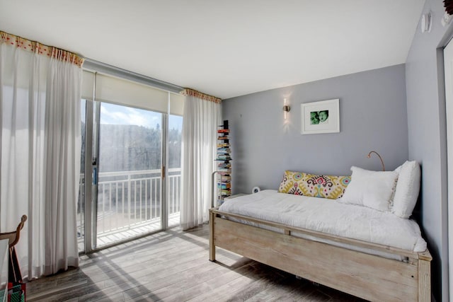 bedroom featuring access to exterior and wood-type flooring