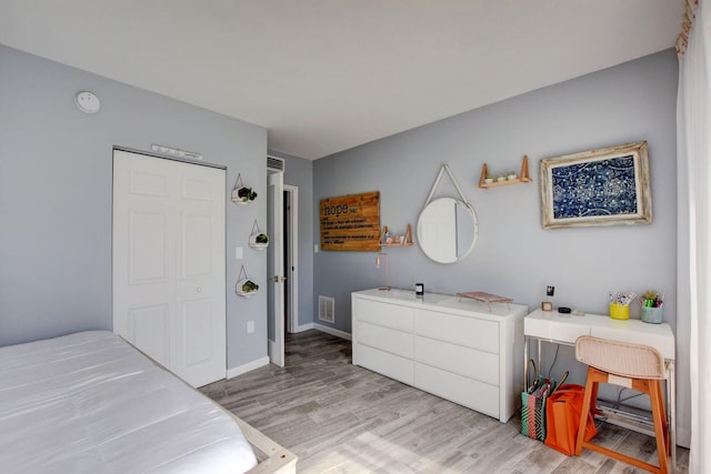 bedroom with light hardwood / wood-style floors and a closet