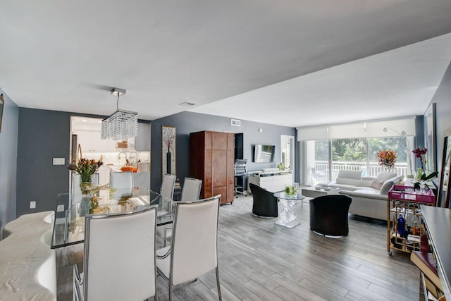 dining space featuring a chandelier and light hardwood / wood-style floors