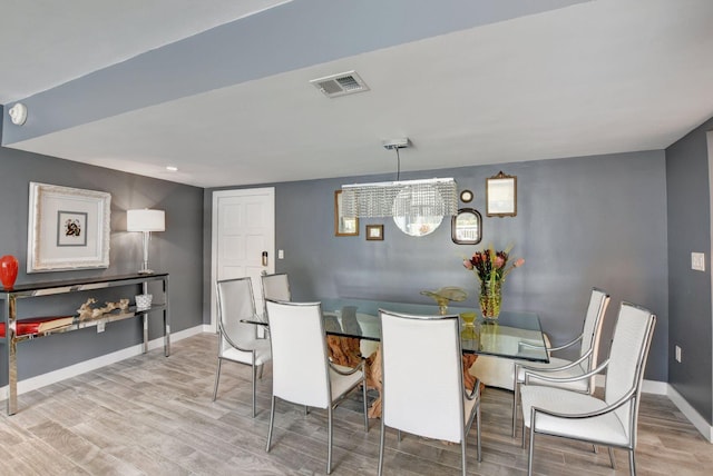 dining area with a chandelier and light hardwood / wood-style flooring