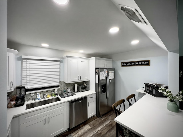 kitchen featuring appliances with stainless steel finishes, dark hardwood / wood-style floors, sink, and white cabinets