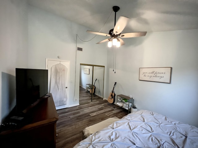 bedroom with a closet, high vaulted ceiling, dark hardwood / wood-style floors, and ceiling fan