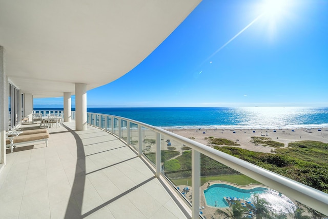 balcony with a water view and a beach view