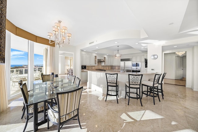 dining room with a raised ceiling and a notable chandelier