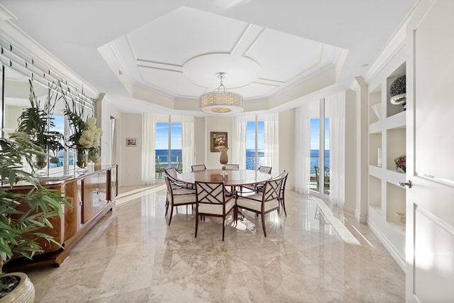 dining room with crown molding, a water view, and built in shelves