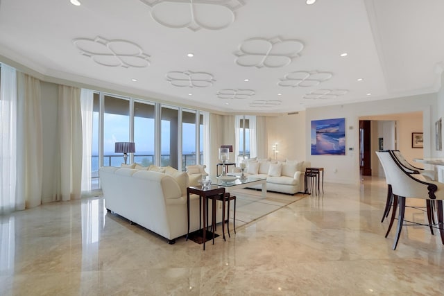 living room featuring crown molding, a water view, and expansive windows