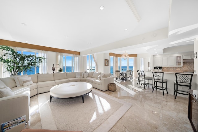 living room featuring a water view and a chandelier