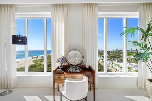 dining area with a water view, a healthy amount of sunlight, and a beach view