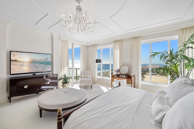 bedroom featuring multiple windows, a water view, carpet flooring, and a notable chandelier