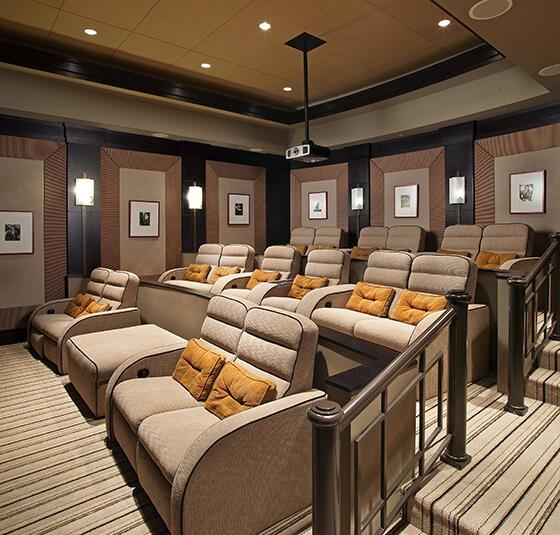 home theater room featuring a raised ceiling and light carpet