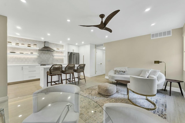 living room featuring ceiling fan and light hardwood / wood-style flooring