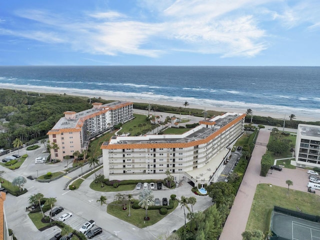 birds eye view of property with a water view and a beach view