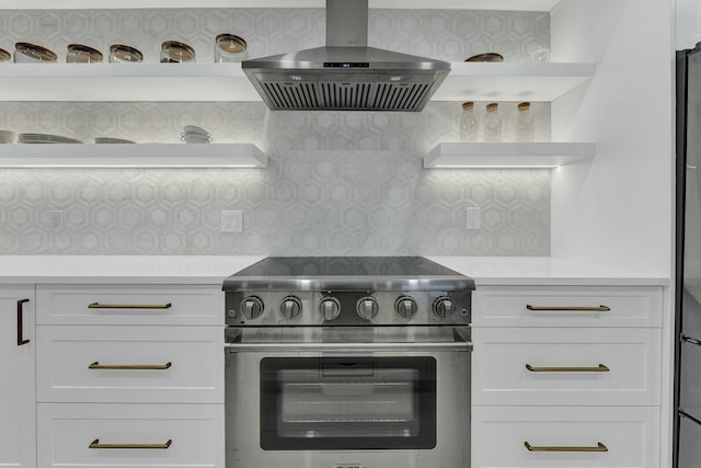 kitchen featuring range hood, decorative backsplash, white cabinets, and high end range