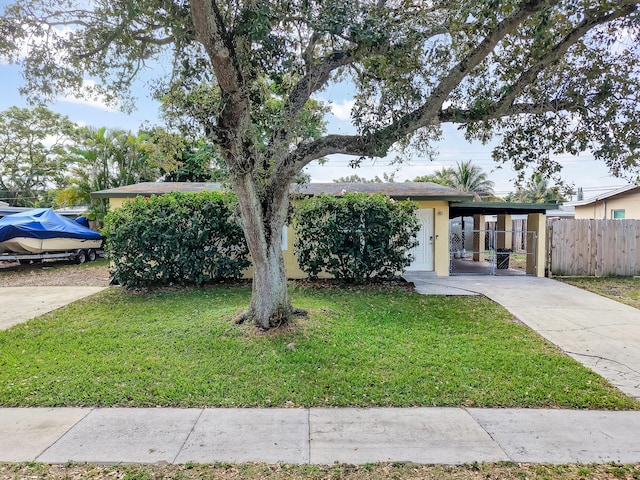 view of front of property featuring a front lawn and a carport