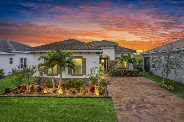 mediterranean / spanish-style house with a lawn